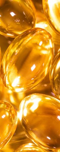 Bright close-up image of golden gel capsules, ideal for health and wellness themes.